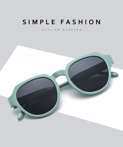 Detail of light green thick frame sunglasses with dark lenses on a minimalist background