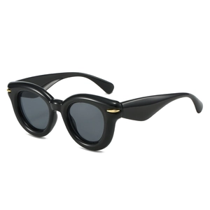 Chic black oval puffy sunglasses with gold metal accents on sleek temples