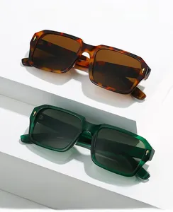 Close-up of tortoise and dark green square sunglasses with golden arrow temple detail