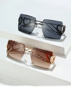 Détail de lunettes de soleil carrées sans monture avec cœurs métalliques sur les branches