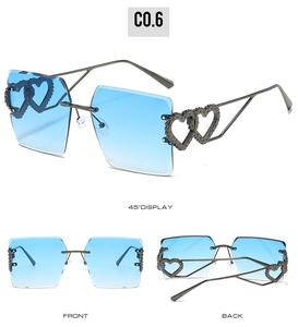 Détail de lunettes de soleil sans monture à cœur avec verres dégradés bleus et décorations