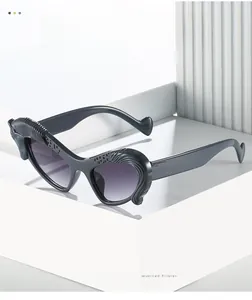 Close-up of cat-eye sunglasses featuring textured frame detail and gradient purple lenses
