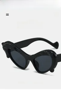 Detail of black heart-shaped sunglasses with wavy texture and premium acetate finish