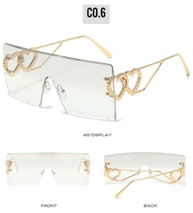 Detail einer randlosen quadratischen Sonnenbrille mit goldenen Bügeln und Herz-Muster