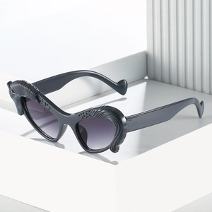 Fashionable cat eye sunglasses with textured wave frames and dark gradient lenses