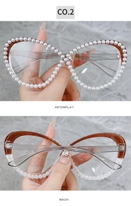 Close-up of cat-eye glasses with pearl trim and heart-shaped rhinestone on bridge