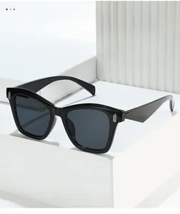 Detail of black cat-eye sunglasses with silver U-shaped metal accents on high-quality frames