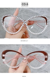 Detail view of pearl-embellished cat-eye glasses with brown gradient frames and rhinestones
