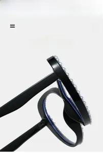 Detail of black cat-eye glasses frame featuring hand-set pearls on the upper rim