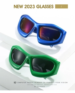 Gros plan sur lunettes de soleil Y2K à monture épaisse bleue et verte avec verres dégradés