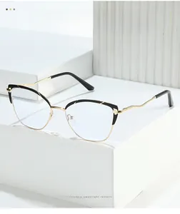 Detail of cat-eye glasses frame featuring gold wavy temples and black-gold hybrid design