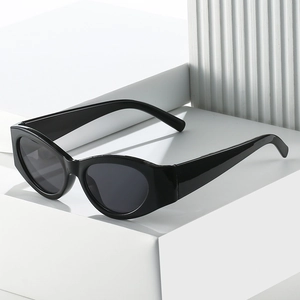 Retro black oval cat eye sunglasses with dark grey lenses on minimalist white background