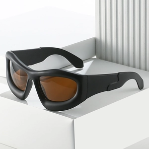 Lunettes de soleil Y2K noir mat futuristes avec verres ambrés sur support géométrique