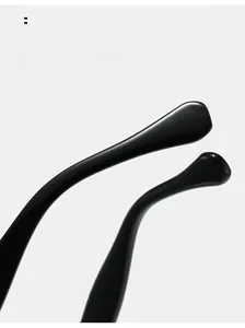 Macro shot of glossy black curved temple legs on minimalist round glasses frames