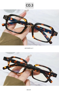 Macro detail of amber tortoiseshell square frame glasses with metal rivets and CE markings