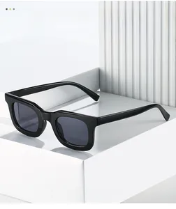 Close-up of black square sunglasses on white geometric blocks with texture detail
