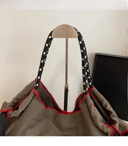 Dettaglio della borsa tote in tessuto Oxford con bordi a contrasto e manici intrecciati