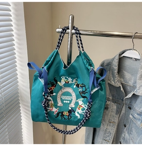 Dettaglio del ricamo a cavallo e logo ferro di cavallo su borsa Oxford verde