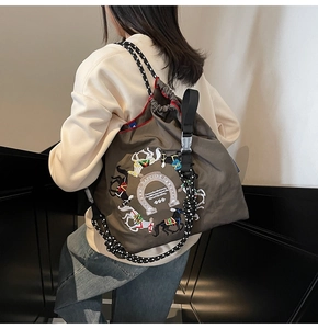 Dettaglio della borsa tote in nylon grigio con ricamo cavallo e tracolla in corda intrecciata