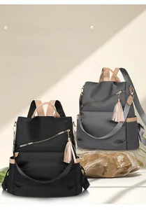 Detail showing anti-theft back zipper and tassel charm on black and gray backpacks