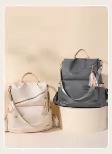 Close-up of dual-color anti-theft backpacks with water-resistant nylon and tassel details