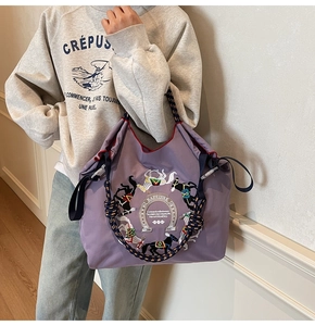 Dettaglio borsa shopper viola con ricamo di cavalli e manici in corda intrecciata