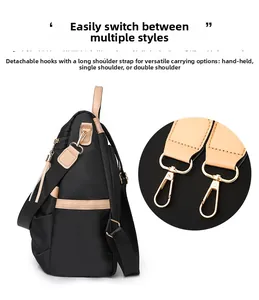 Detail view of black nylon backpack featuring adjustable straps and metal clip hooks