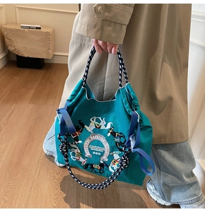Dettaglio della borsa tote in nylon verde con ricamo di cavallo e manici in corda