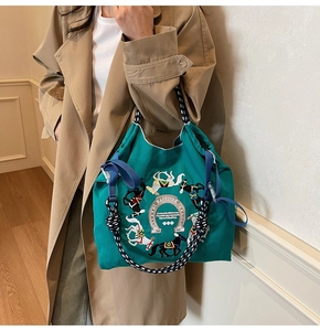Dettaglio della borsa tote verde smeraldo in tessuto oxford con ricamo e manici in corda