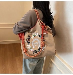 Dettaglio del ricamo a cavallo su una borsa tote oxford con manici in corda colorati