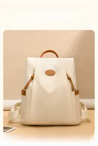 Detail of waterproof nylon backpack showing side pockets and premium leather handle