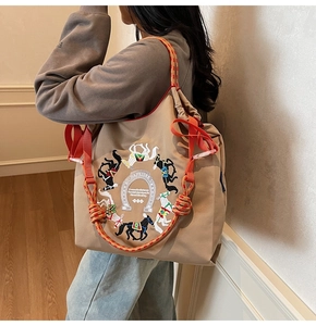 Dettaglio della borsa tote oxford kaki con ricamo di cavallo colorato e coulisse arancione acceso