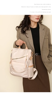 Detail of beige nylon backpack with leather handle and fringe tassel on female model