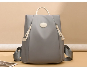Close-up of waterproof Oxford fabric and grey backpack with cream leather accents
