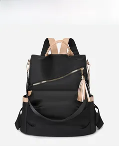 Detail of black nylon backpack featuring diagonal zipper with stylish leather fringe tassel