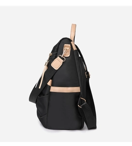 Side view of black nylon backpack with beige leather trim and gold-tone hardware