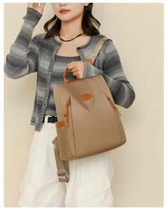 Detail of adjustable champagne nylon straps and khaki oxford fabric on an anti-theft backpack