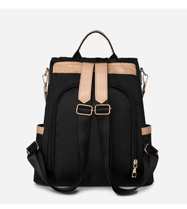 Detail view of the black waterproof fabric and khaki leather straps on this backpack