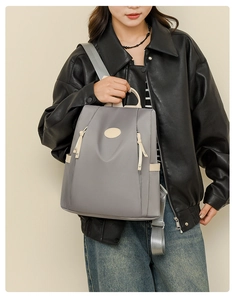 Detail of waterproof grey oxford backpack with adjustable straps worn by a model