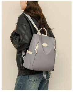Detail of light gray waterproof oxford backpack with side pockets on a model