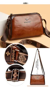 Detail of detachable ethnic pattern wide strap on brown vintage oil wax leather bag