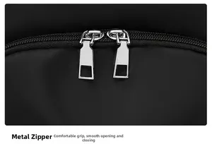 Detail of smooth silver dual metal zippers on waterproof black nylon travel backpack