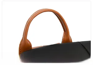 Detail of the brown leather handle and waterproof oxford fabric on the travel backpack