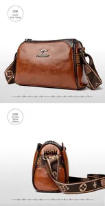 Detail view of brown vintage leather pillow bag with floral strap and metal logo