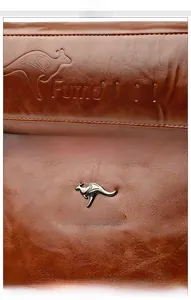 Macro detail of luxury oil-wax leather texture with embossed and metallic hardware logo