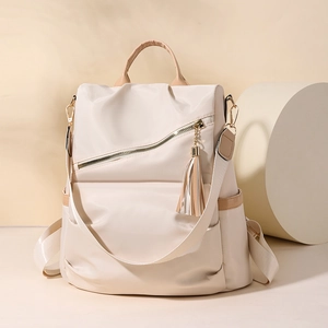 Minimalist beige nylon backpack for women with brown leather accents and tassel detail