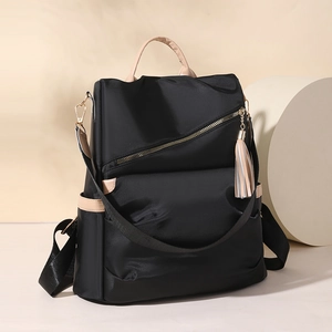 Minimalist black nylon women backpack with beige leather accents and tassel detail