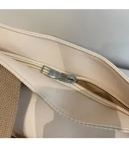 Detail of high-density canvas tote with smooth metal zipper and brown woven strap