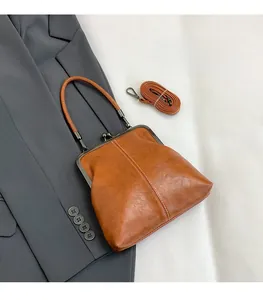 Brown retro crossbody bag shown styled with a blazer featuring metal clasp and top handle
