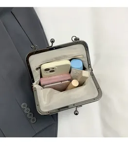 Detail view of the shell purse interior featuring herringbone lining and metal clasp closure